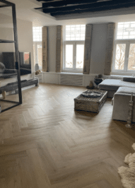 Julia warm eiken walvisgraat Visgraat XL PVC vloer van Stile Floors – realistische houtlook voor woonkamer en slaapkamer.