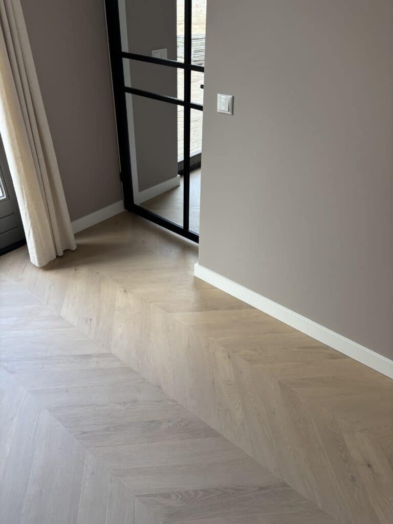 Hongaarse punt Julia greige eiken PVC vloer van Stile Floors – warme houtlook voor huiselijke ruimtes.